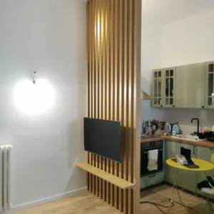 Parete a listelli di legno e arredi su misura