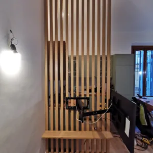 Parete a listelli di legno e arredi su misura